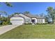 Charming single-story home with a well-manicured lawn and gray exterior at 11134 Horned Owl Rd, Weeki Wachee, FL 34614