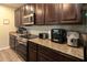 Close-up of a modern kitchen with granite countertops, stainless steel appliances, and dark wood cabinets at 11134 Horned Owl Rd, Weeki Wachee, FL 34614