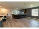 Open-concept living room featuring wood floors, a large sectional, and a wall-mounted TV at 11134 Horned Owl Rd, Weeki Wachee, FL 34614