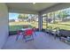 This screened-in patio is equipped with a table, chairs, and a view of the spacious backyard at 11134 Horned Owl Rd, Weeki Wachee, FL 34614