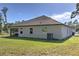 Rear exterior view of the home, featuring a screened in lanai and backyard at 11134 Horned Owl Rd, Weeki Wachee, FL 34614