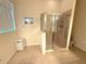 Tiled bathroom features a glass-enclosed shower and a window for natural light at 11204 Clear Oak Cir, New Port Richey, FL 34654