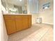 Bathroom with wood cabinets, tiled floor, and plenty of counter space at 11204 Clear Oak Cir, New Port Richey, FL 34654