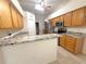 Open kitchen featuring granite countertops, a stainless steel refrigerator, and wood cabinets at 11204 Clear Oak Cir, New Port Richey, FL 34654