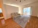 Bright living room with hardwood floors, a comfortable couch, and sliding glass doors leading to an outdoor space at 11204 Clear Oak Cir, New Port Richey, FL 34654