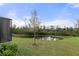 Backyard pond with a single tree in the foreground and lush vegetation on a sunny day at 17026 Shell Bay Dr, Land O Lakes, FL 34638