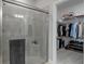 Walk-in shower with glass enclosure, shelving, and adjacent walk-in closet at 17026 Shell Bay Dr, Land O Lakes, FL 34638