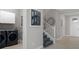 This entryway showcases stairs leading to the second floor, next to the laundry room and garage entrance at 17026 Shell Bay Dr, Land O Lakes, FL 34638