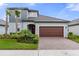 Inviting two-story home showcasing a well-manicured lawn and a brick paved driveway to the two-car garage at 17026 Shell Bay Dr, Land O Lakes, FL 34638