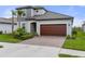 Charming home with a brick paved driveway leading to a two-car garage and a beautifully landscaped front yard at 17026 Shell Bay Dr, Land O Lakes, FL 34638