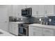 Modern kitchen boasts white cabinets, stainless steel appliances, and a tile backsplash at 17026 Shell Bay Dr, Land O Lakes, FL 34638