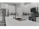 Modern kitchen boasts white cabinets, stainless steel appliances, a tile backsplash, and a spacious quartz countertop at 17026 Shell Bay Dr, Land O Lakes, FL 34638