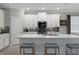 Modern kitchen boasts white cabinets, stainless steel appliances, a tile backsplash, and an island with barstool seating at 17026 Shell Bay Dr, Land O Lakes, FL 34638