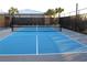 Outdoor pickleball court featuring a blue court with a net, and a black fence surrounding it at 17026 Shell Bay Dr, Land O Lakes, FL 34638
