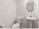 Powder room with stylish pedestal sink, modern fixtures, and ample space provides convenience for guests at 18629 Coastal Shore Ter, Land O Lakes, FL 34638