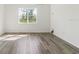Bright room featuring wood flooring, a large window providing ample light and a nature view at 18629 Coastal Shore Ter, Land O Lakes, FL 34638