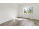 A bright room featuring wood flooring, and a window providing natural light and a view of the outside at 18629 Coastal Shore Ter, Land O Lakes, FL 34638