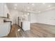 An open kitchen and living room, featuring an island, stainless appliances, and hardwood floors at 18629 Coastal Shore Ter, Land O Lakes, FL 34638
