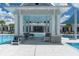 Luxurious pool with covered seating area featuring comfortable chairs and tables, perfect for relaxation at 18629 Coastal Shore Ter, Land O Lakes, FL 34638