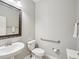 Well-lit powder bathroom with a pedestal sink, toilet, and decorative mirror at 19504 Lily Pond Ct, Brooksville, FL 34601