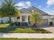 Charming single-story home with a well-manicured lawn and a welcoming front porch, complemented by vibrant palm trees at 19504 Lily Pond Ct, Brooksville, FL 34601