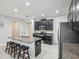 Open concept kitchen with island seating, stainless appliances, and dark cabinetry at 19504 Lily Pond Ct, Brooksville, FL 34601