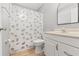 Bathroom featuring white vanity with chrome hardware, toilet, and shower with patterned leaf shower curtain at 4503 Higate Rd, Spring Hill, FL 34609