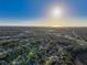 Expansive aerial view of a sun-drenched neighborhood with commercial area on the horizon at 5518 Pinehurst Dr, Spring Hill, FL 34606
