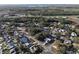 Aerial view of a residential neighborhood showcasing a mix of homes near a wooded area and roadways at 5518 Pinehurst Dr, Spring Hill, FL 34606