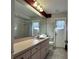 Neutral bathroom featuring an expansive mirror, neutral walls, and white toilet and vanity at 5518 Pinehurst Dr, Spring Hill, FL 34606