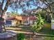 Quaint single-story home with a red tile roof, framed by mature trees and lush landscaping at 5518 Pinehurst Dr, Spring Hill, FL 34606
