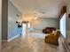 Spacious living room with tile flooring, ceiling fan, and a view into the dining area at 5518 Pinehurst Dr, Spring Hill, FL 34606