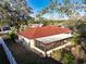 Home with a red roof, screened in patio, and mature trees on a large lot at 5518 Pinehurst Dr, Spring Hill, FL 34606