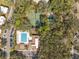 An aerial view showcases the community pool, tennis court, and lush green surroundings in this community at 6002 Laketree Ln # L, Temple Terrace, FL 33617