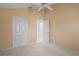 Neutral bedroom with a ceiling fan, double closet doors, and a door leading to another room at 6323 Cardinal Crest Dr, New Port Richey, FL 34655