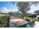 Exterior shot of bocce ball court with seating and mature landscaping at 6323 Cardinal Crest Dr, New Port Richey, FL 34655