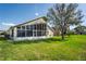 Exterior view of the sunroom and rear of the home, with well-maintained lawn and landscaping at 6323 Cardinal Crest Dr, New Port Richey, FL 34655