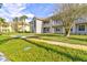 Charming condo featuring a well-manicured lawn, vibrant palm trees, and a inviting outdoor walkway at 6734 Dali Ave # 205, Land O Lakes, FL 34637