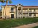Inviting two-story condo building with balconies, green lawn, and beautiful landscaping at 6734 Dali Ave # 205, Land O Lakes, FL 34637