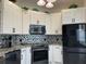 Modern kitchen with white cabinets, stainless steel appliances, and stylish backsplash at 6734 Dali Ave # 205, Land O Lakes, FL 34637