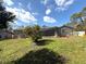 Spacious backyard featuring a lovely green lawn and an inviting screened-in pool at 7090 Red Oak Loop, New Port Richey, FL 34654