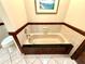 Bathroom boasts a beige bathtub with decorative tile and custom dark wood cabinetry at 7090 Red Oak Loop, New Port Richey, FL 34654