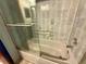 Bathroom showcases a tiled bathtub with glass doors and chrome fixtures at 7090 Red Oak Loop, New Port Richey, FL 34654