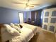 Relaxing bedroom with soft carpet, ample lighting, large closet, and a ceiling fan at 7090 Red Oak Loop, New Port Richey, FL 34654