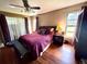 Comfortable bedroom featuring wood floors, a ceiling fan, and large windows for plenty of natural light at 7090 Red Oak Loop, New Port Richey, FL 34654