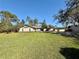 Charming home with a well-manicured front lawn, mature trees, and an inviting facade at 7090 Red Oak Loop, New Port Richey, FL 34654