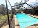 Enjoy this screened-in pool surrounded by brick pavers and lush greenery at 7090 Red Oak Loop, New Port Richey, FL 34654