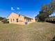 Spacious backyard view reveals a well-kept lawn, large shade tree and the exterior of the home at 9332 Whitstone Ct, New Port Richey, FL 34655