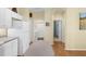 Functional kitchen featuring white appliances and cabinets with easy access to laundry and bathroom at 9819 Bridgeton Dr, Tampa, FL 33626