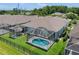 Aerial view of the screened in pool, set in a lush backyard with a black metal fence at 9819 Bridgeton Dr, Tampa, FL 33626
